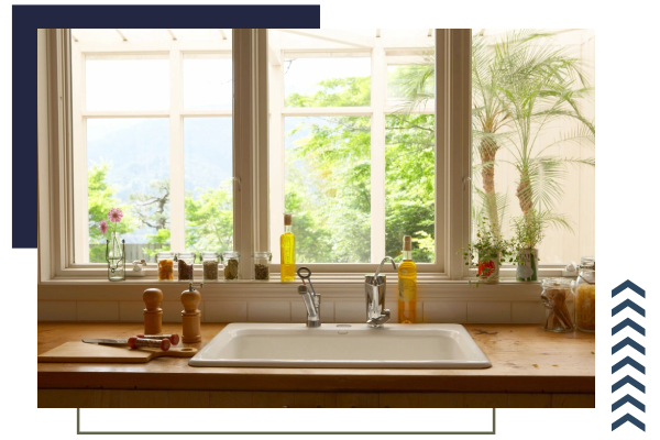 A kitchen sink with a view of the outside.